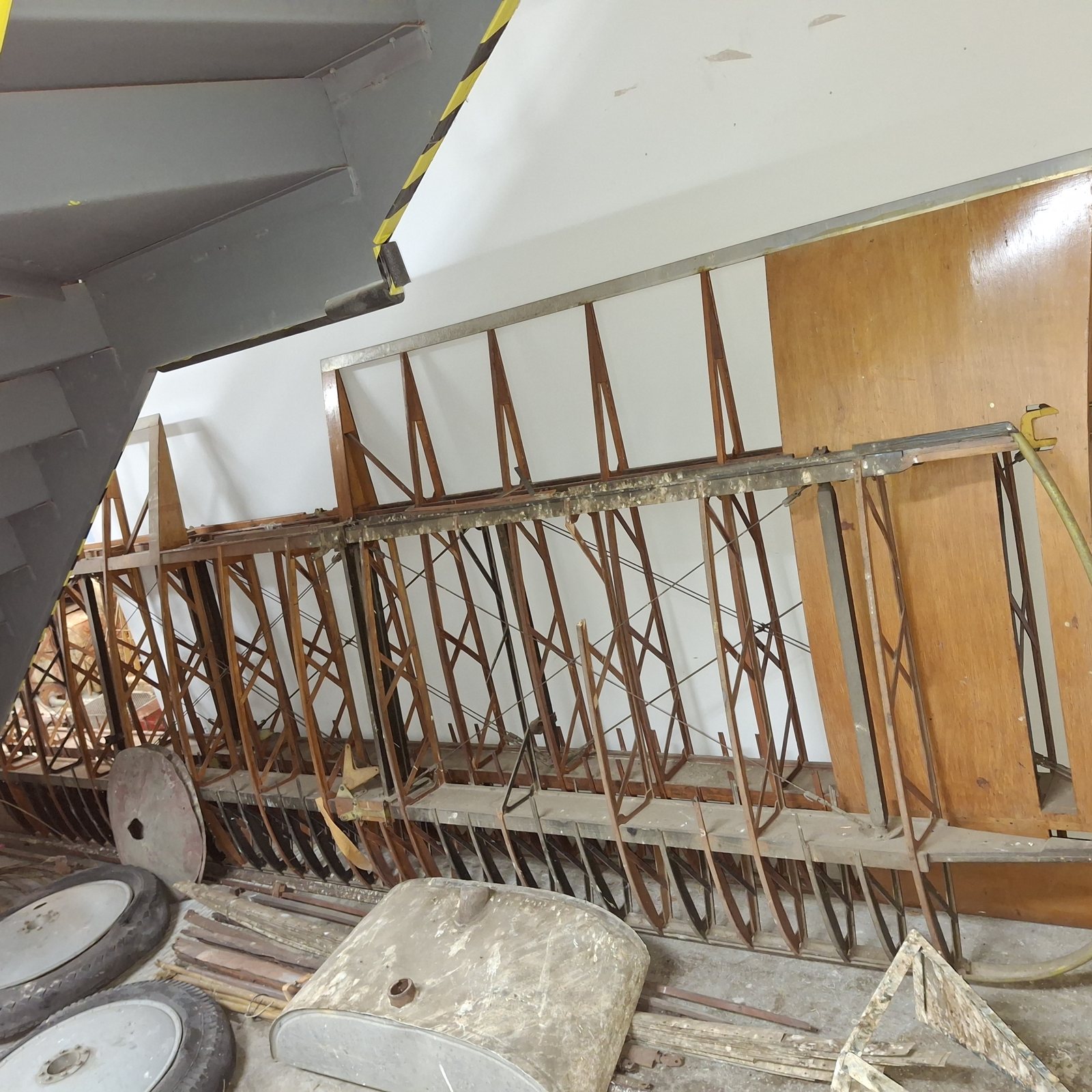 Wing panels, wheels and parts of the Collection's Eaglerock N5910 laid out in a shop.